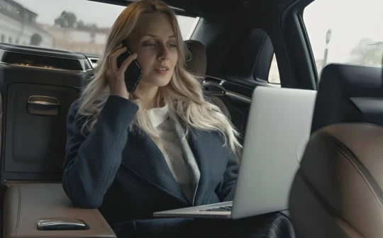Kobieta podróżująca samochodem na tylnym siedzeniu pracująca przy komputerze